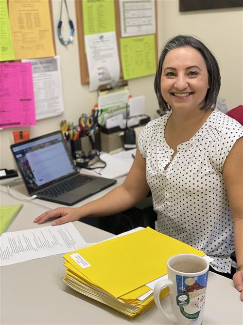 Erika Noone at her desk smiling