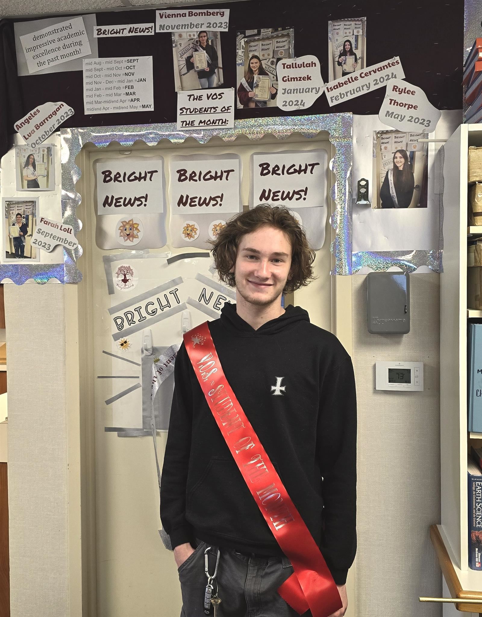  student standing in front of the Bright News! wall