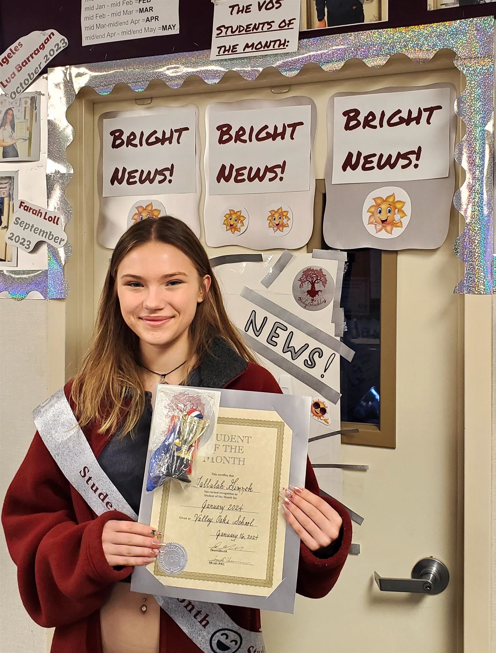  student standing in front of the Bright News! wall