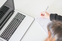 girl taking notes at a computer 