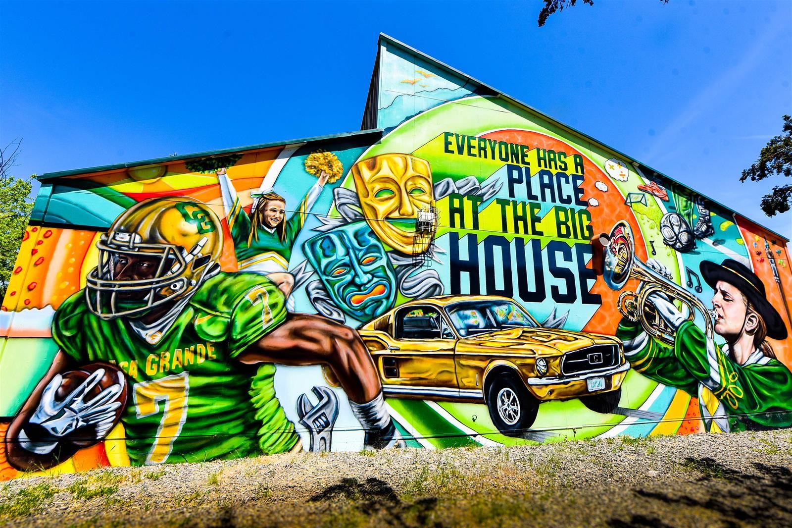 Bright Casa mural that says "everyone has a place at the big house"