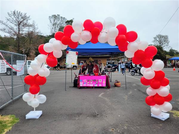 Red and white balloon arch leading into a school event.