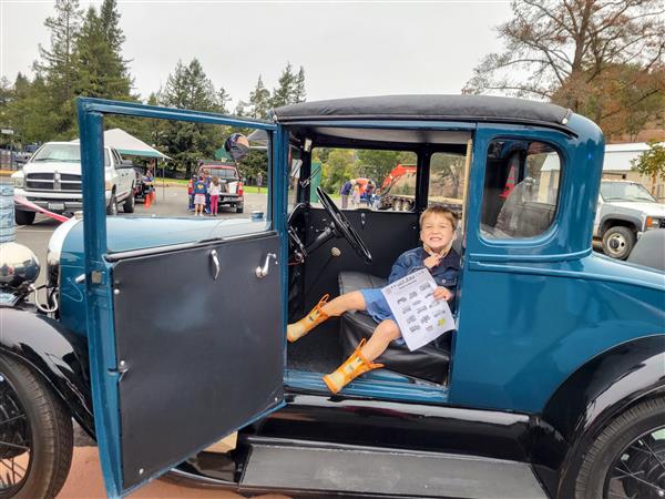 Kindergarten boy smiling in a 1929 Ford Model A.