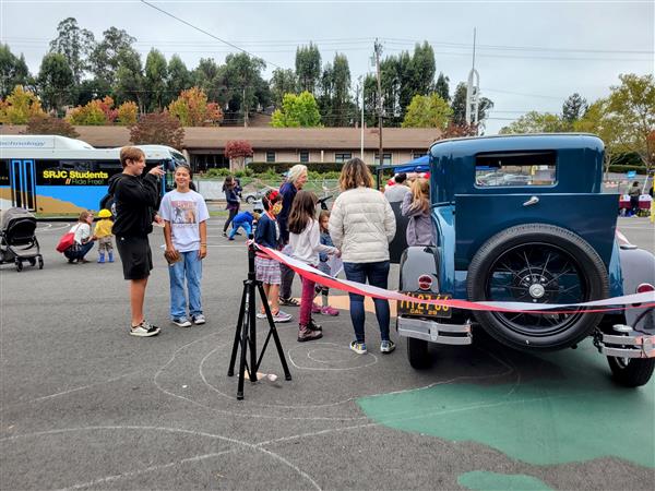 People looking at vehicles at a school event.